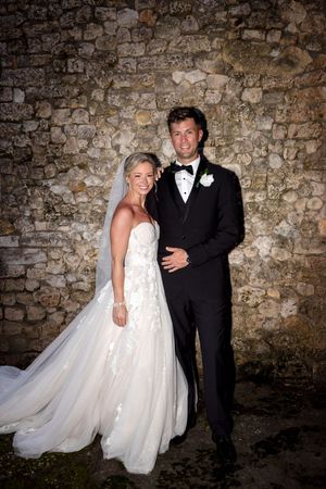 A bride and groom pose together against a rustic stone wall in a series of romantic wedding photos. Casa de Campo
