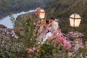 Garden lanterns illuminate a scenic overlook with blooming pink flowers at dusk.