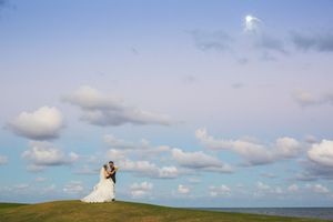 Scenic wedding photos against a dramatic blue sky with white clouds.