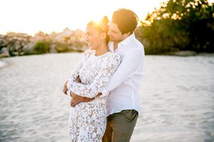 Romantic sunset beach photo session with couple in wedding attire.