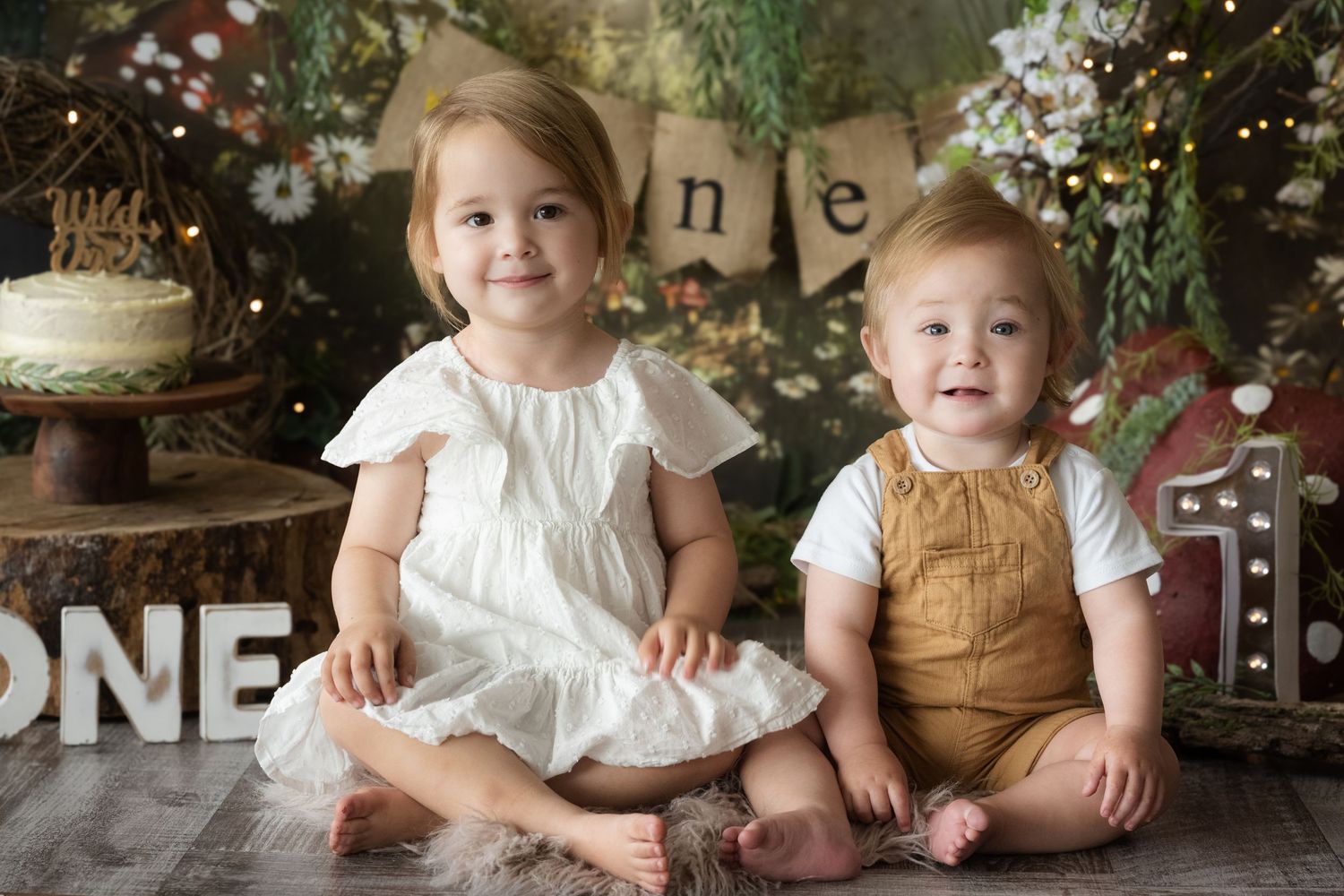 Rustic first birthday cake smash session with woodland decor and natural elements.