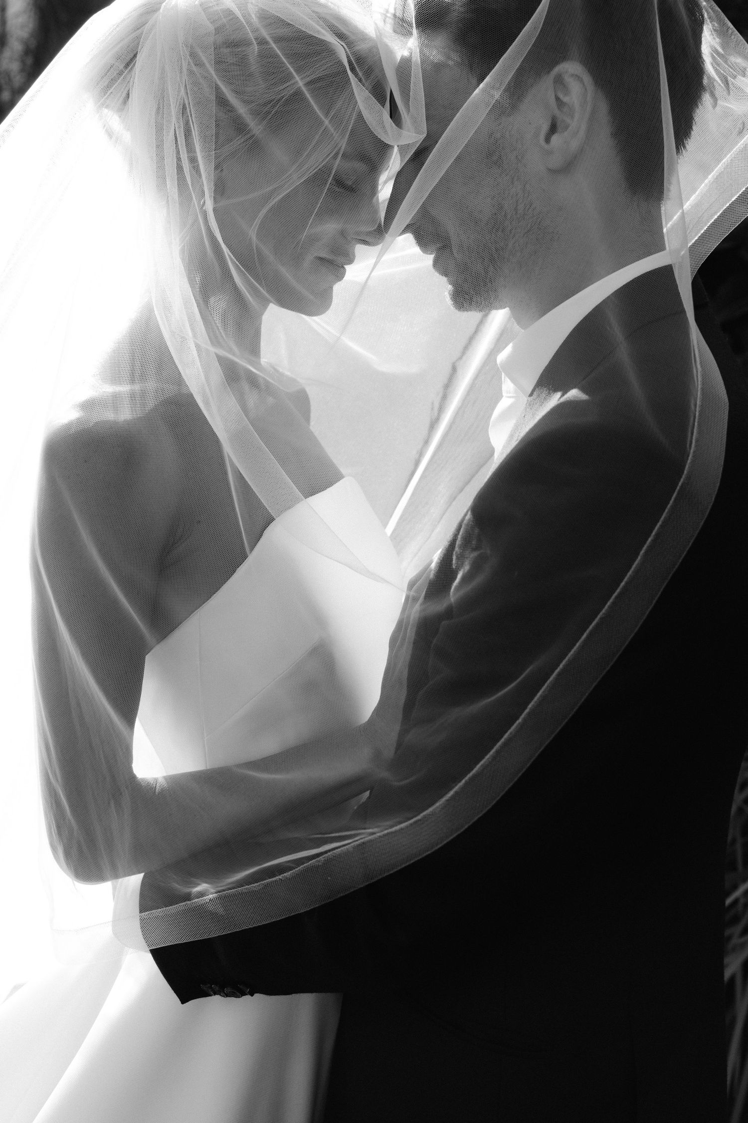 A series of black and white romantic wedding photos showing tender moments between a bride and groom.