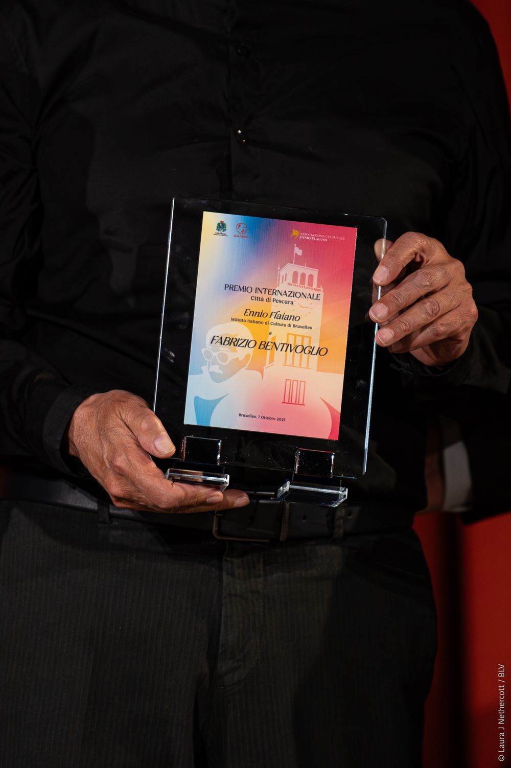 Close-up shots of colorful award certificates or plaques being held and displayed against dark background.