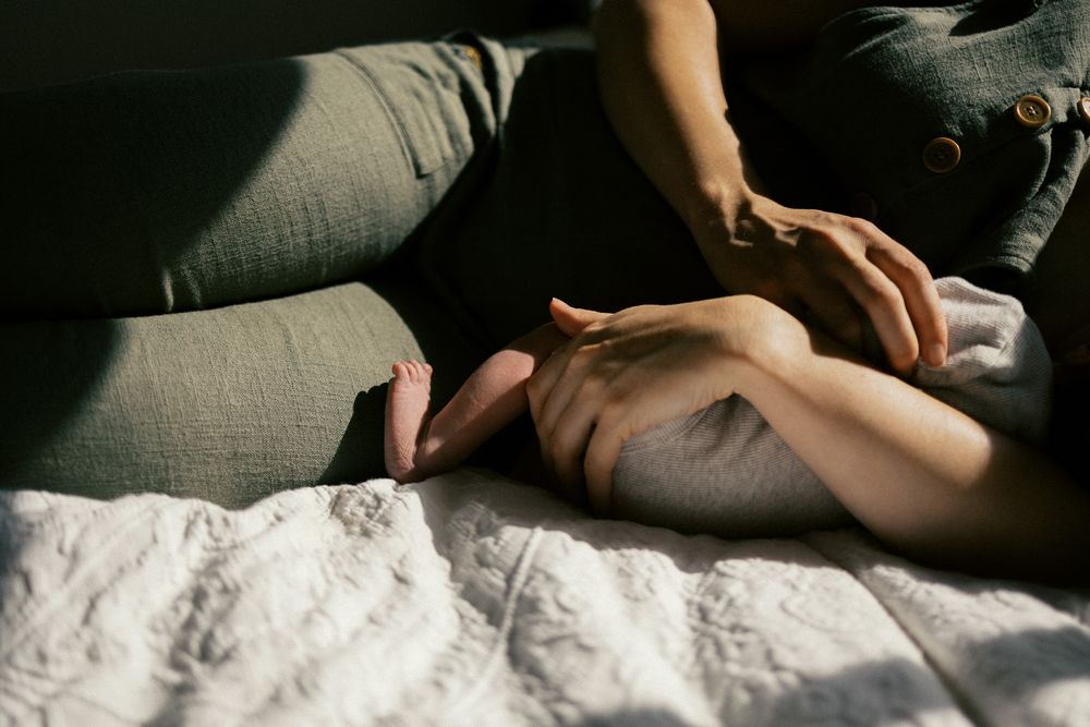 A sequence of intimate black and white photographs showing hands gently resting on fabric in soft natural light.