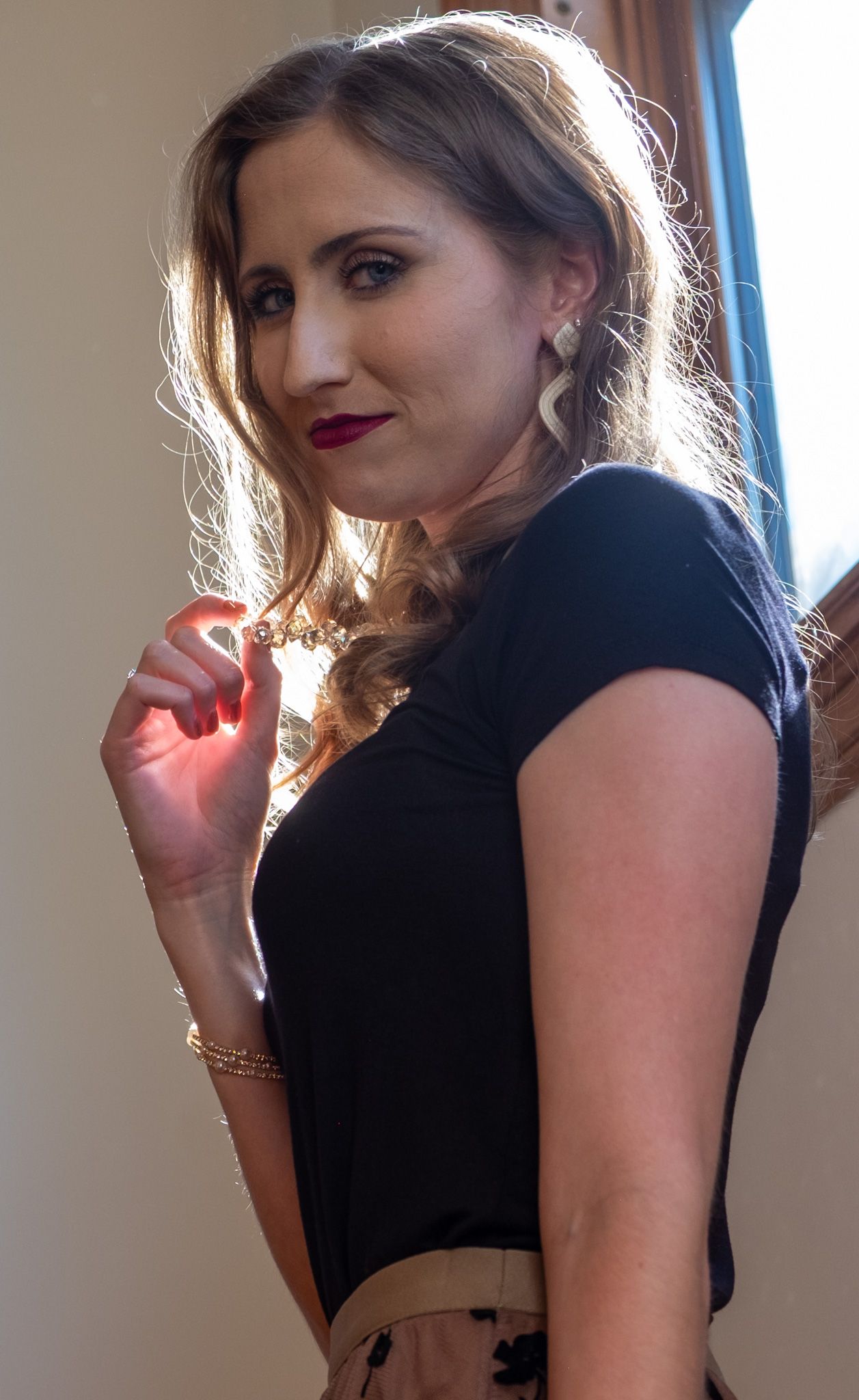 A woman in a black top poses for a series of artistic self-portraits against a light background.