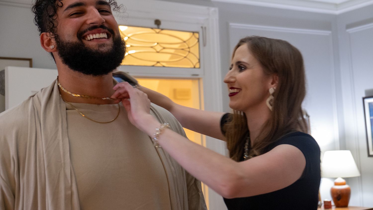 Two people sharing a lighthearted moment together in a brightly lit indoor setting.