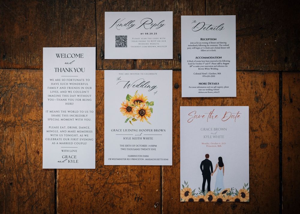 Wedding invitation suite with sunflower design and elegant typography displayed on rustic wooden surface.