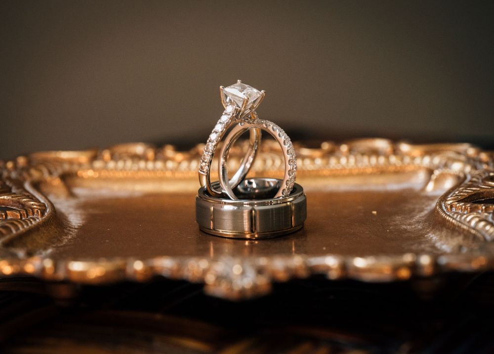 Close-up detail shots of wedding rings with dramatic lighting and reflective surfaces.