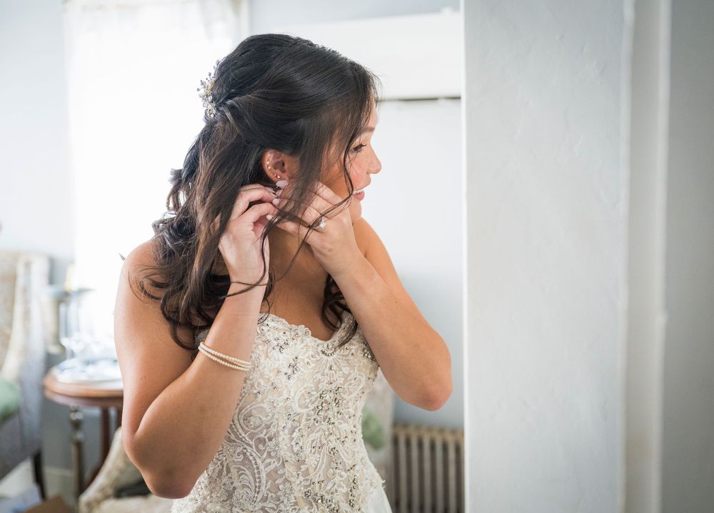 Intimate getting ready moments captured through doorways showing wedding dress details and preparations.