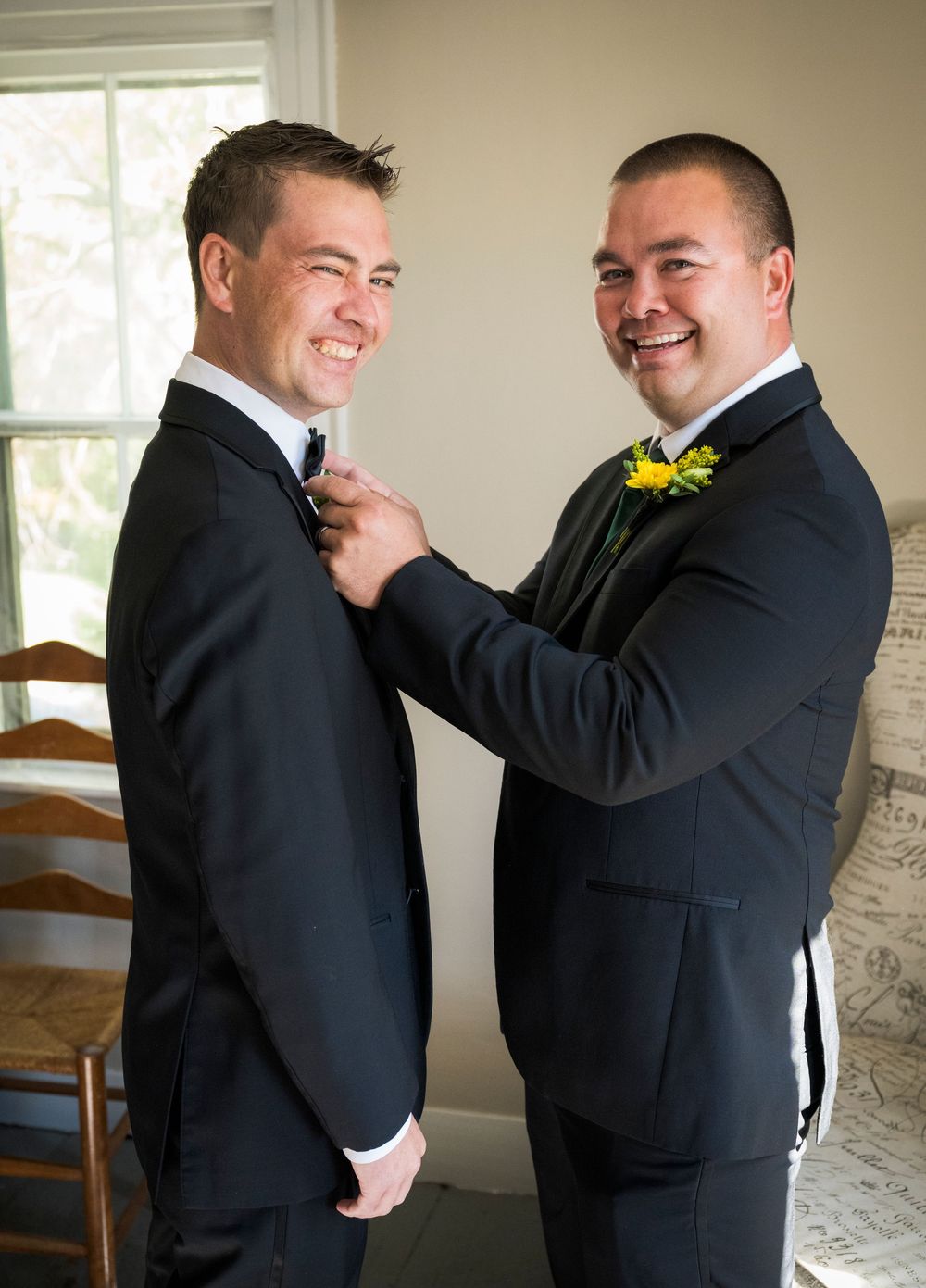 Groomsmen help adjust each other's ties and boutonnieres before the ceremony.