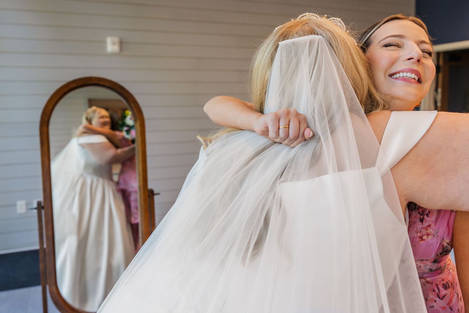 A flowing white wedding dress being fitted and adjusted in preparation for the ceremony.