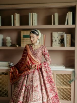 Traditional red and gold embroidered lehenga shown from multiple angles against white built-in cabinets.