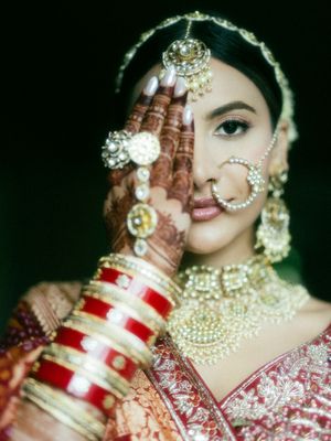 Traditional Indian bridal jewelry and makeup details shown in close-up photos with red and gold accents.