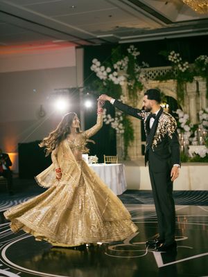 Elegant couple dancing together at a wedding reception with the bride wearing a stunning gold sequined gown.