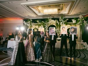 Wedding guests dance and socialize during an elegant evening reception in a luxurious ballroom.