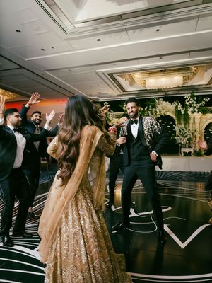 Wedding guests dancing and celebrating on a black and white checkered dance floor at an elegant reception venue.