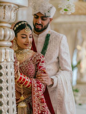 Traditional Indian wedding ceremony with couple in ornate red and white attire during intimate cultural celebration.
