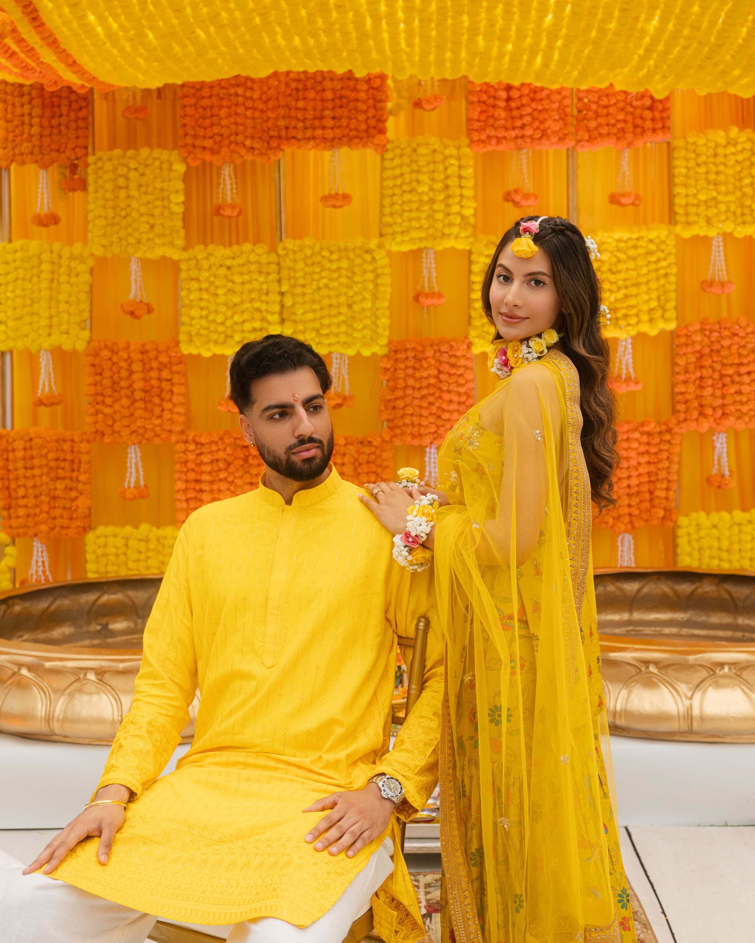 A series of wedding photos showing guests in vibrant yellow and orange traditional Indian attire and decor.