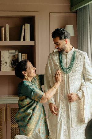 A couple in traditional Indian attire share tender moments in a series of intimate indoor photographs.