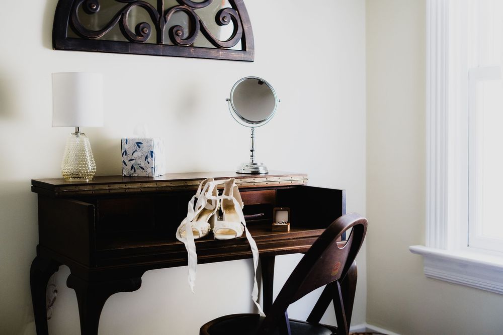 Elegant interior room with white walls featuring dark wooden furniture and decorative elements.