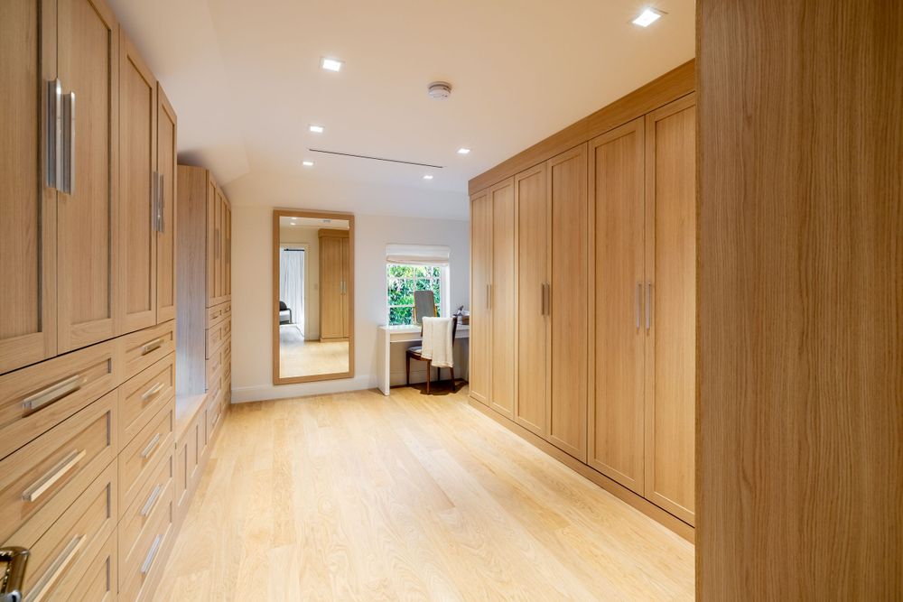 Long hallway with built-in wooden cabinetry and light hardwood flooring.