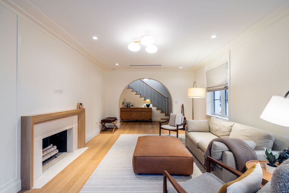 Contemporary living room with fireplace, staircase, and comfortable seating arrangement.