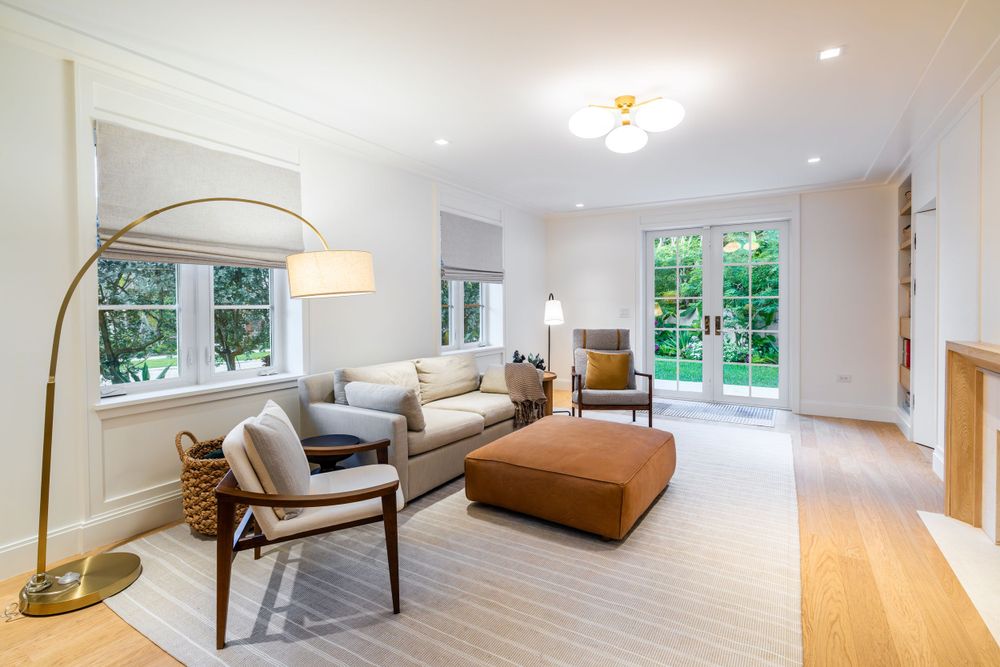 Bright living room with large windows, modern furniture, and hardwood floors.