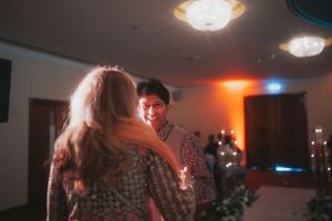 Couple dancing together at a reception with warm ambient lighting.