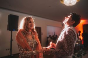 Dancing couple sharing a joyful moment under crystal chandeliers.