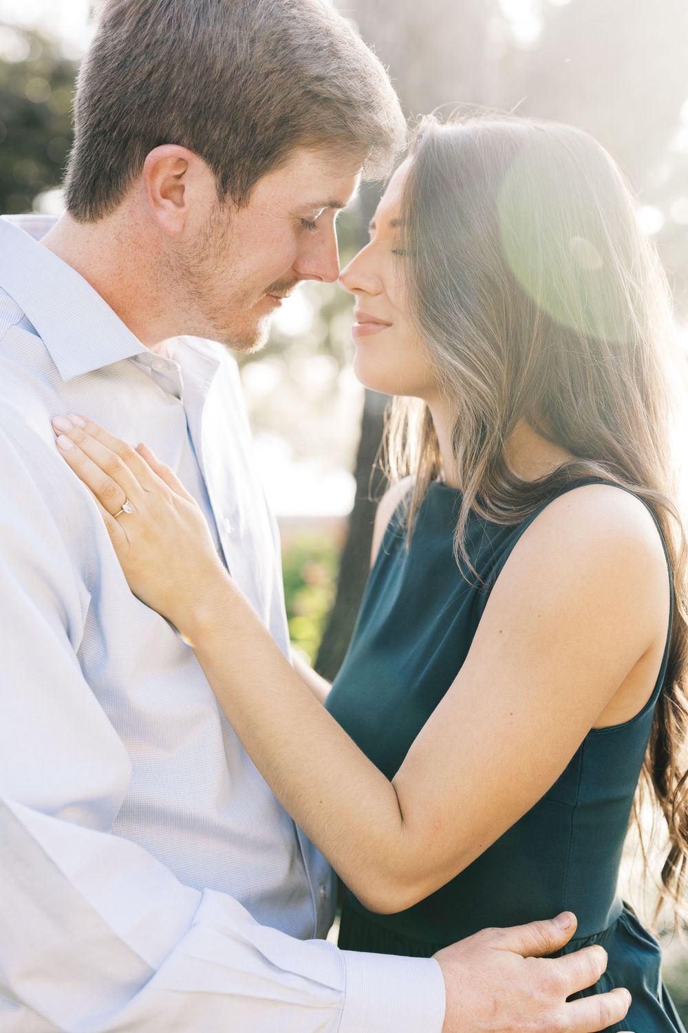 Romantic couple sharing an intimate moment outdoors in glowing sunlight.
