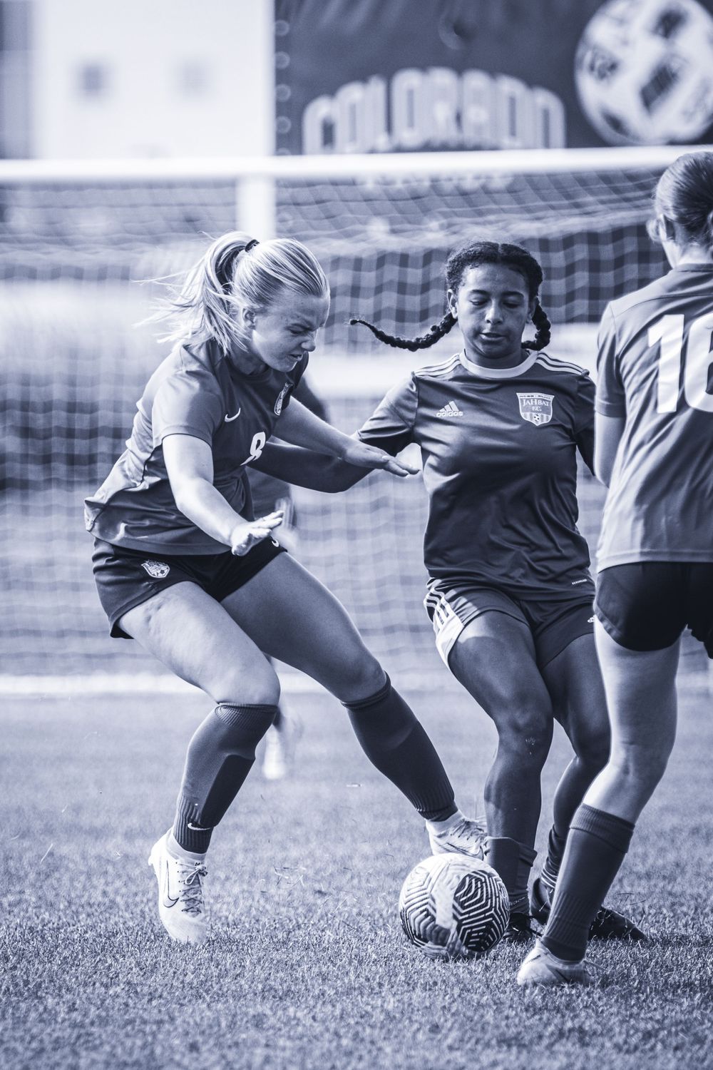 Soccer players battle for ball control during competitive match.