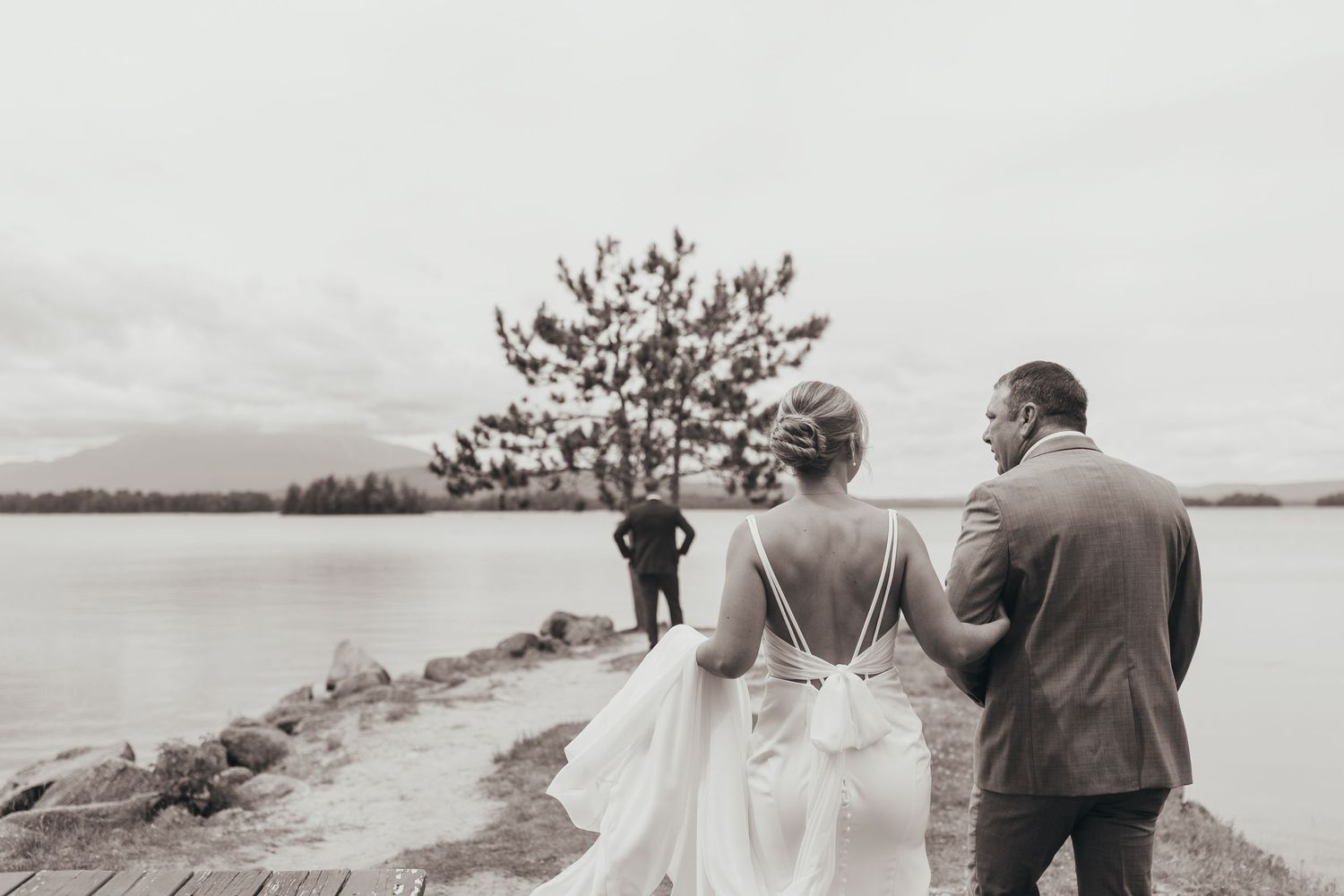 Black and white wedding photos showing couple walking along scenic coastal path.