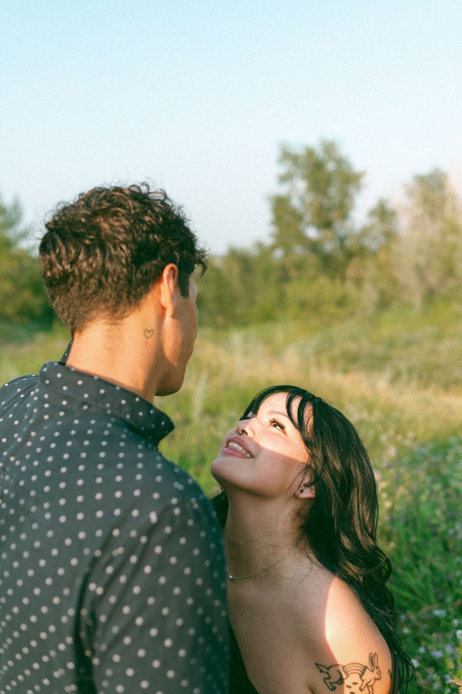 Intimate portrait of couple sharing a tender moment in a summer field.
