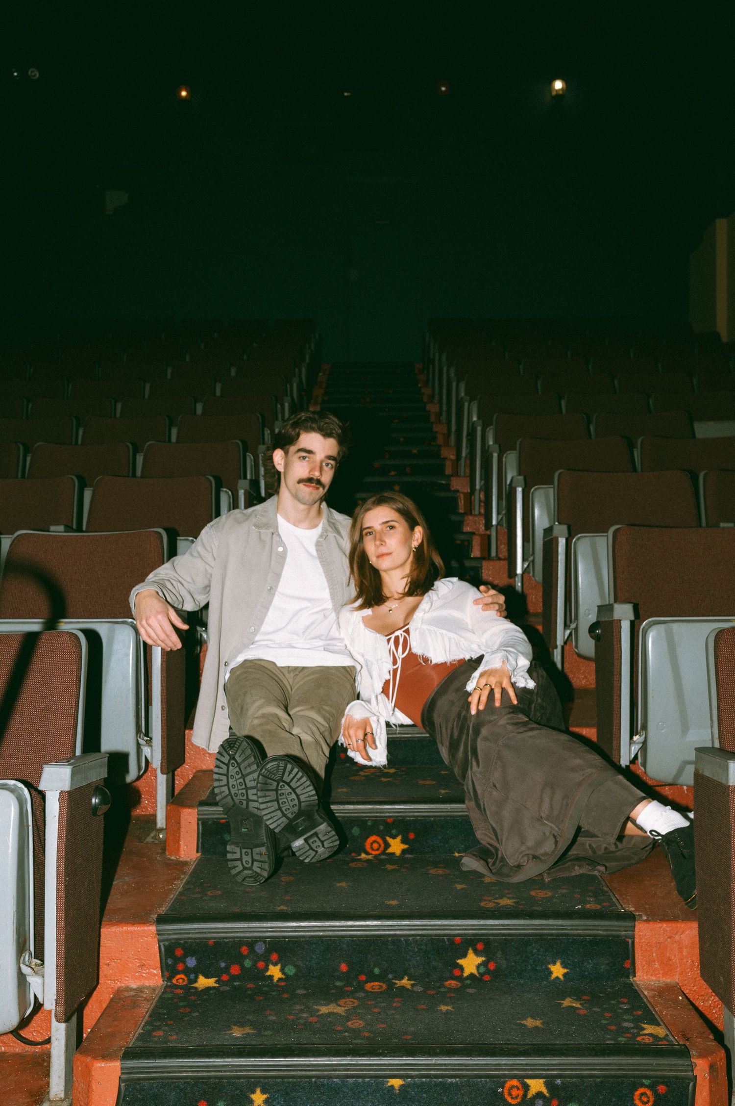 Empty movie theater seats with scattered stars and couple resting in casual poses at the Roxy Theatre, Saskatoon Saskatchewan.