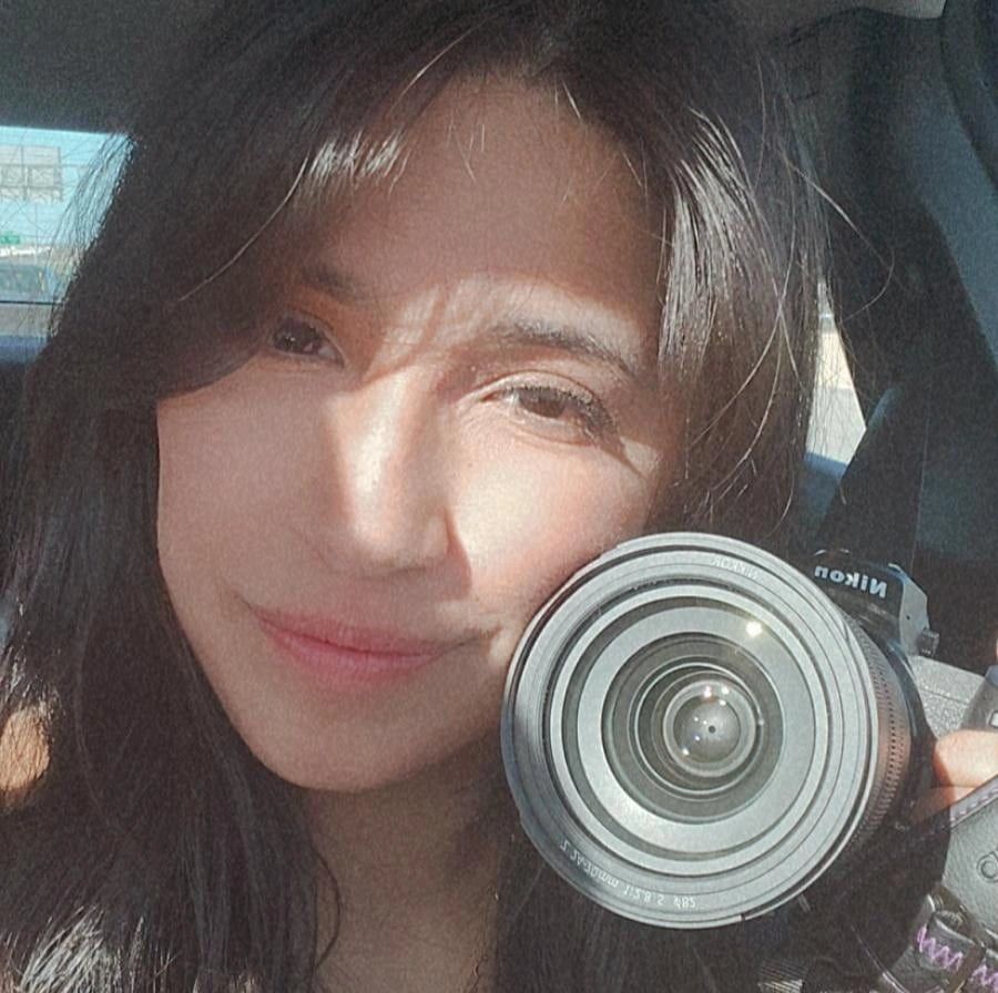 Close up selfie with camera lens in hand.