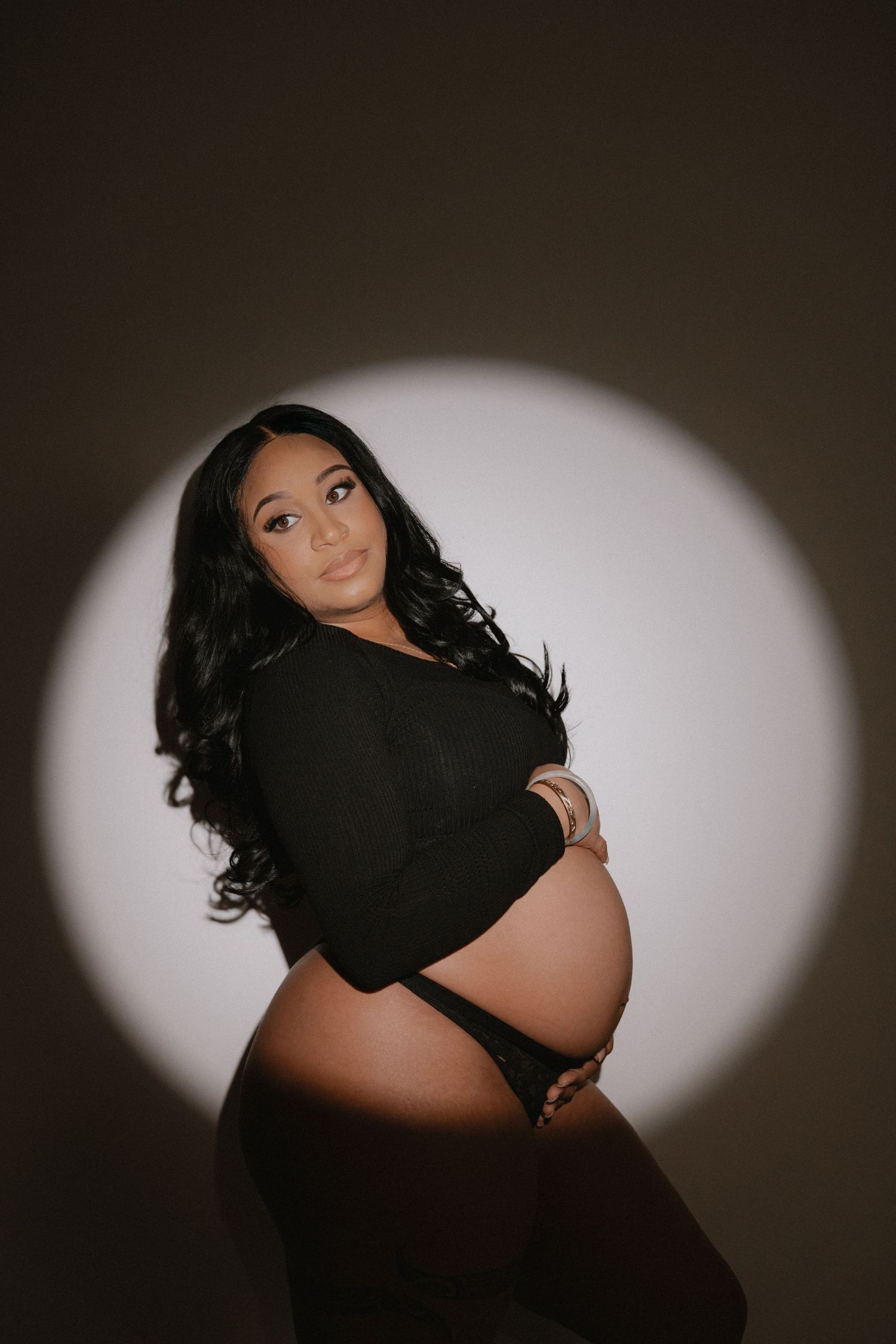 Artistic black and white maternity portrait featuring flowing white shirt.