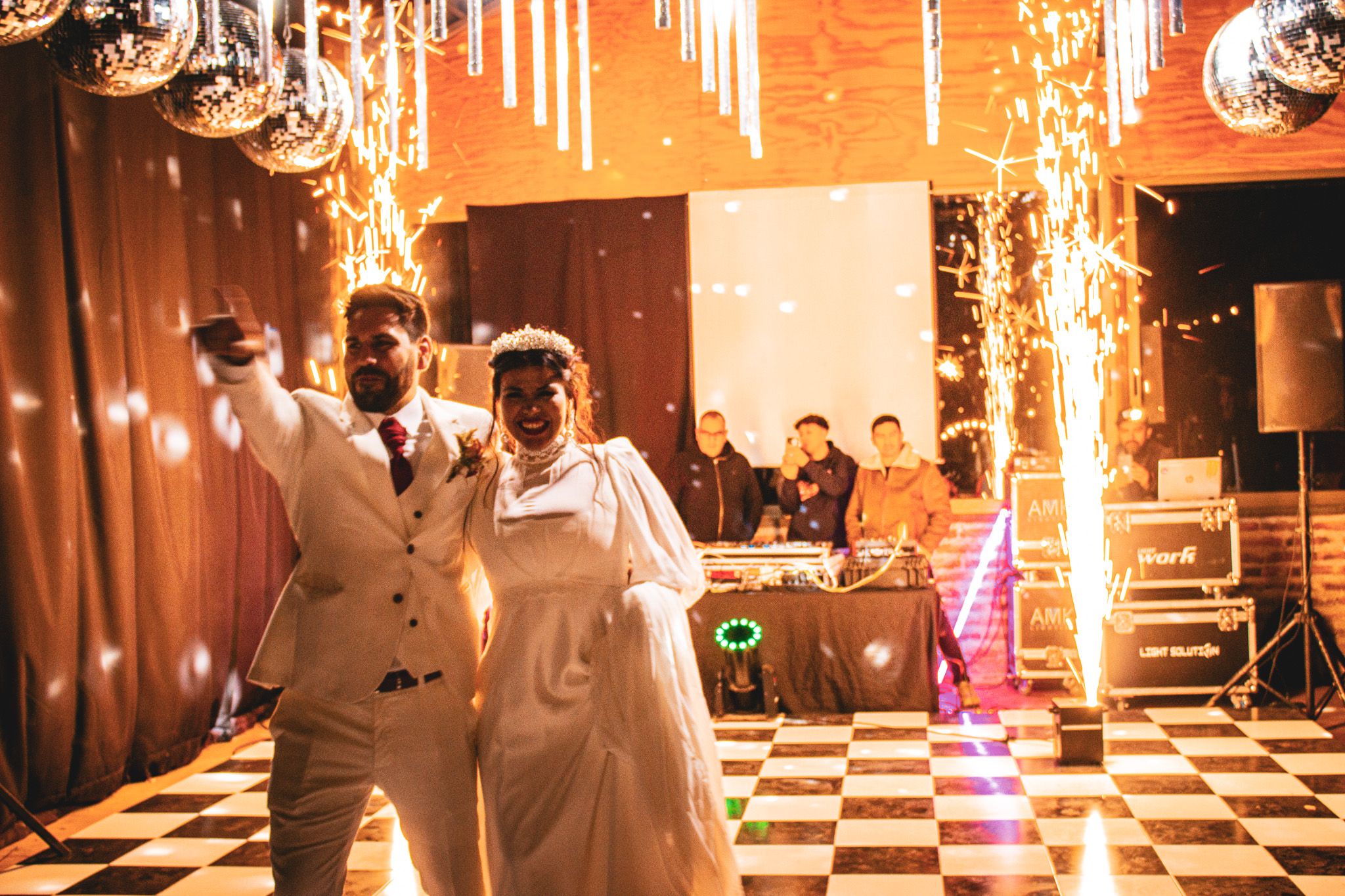 Wedding reception Pista de baile de recepción de matrimonio con efectos floor with dramatic sparkler effects and checkerboard floor pattern.