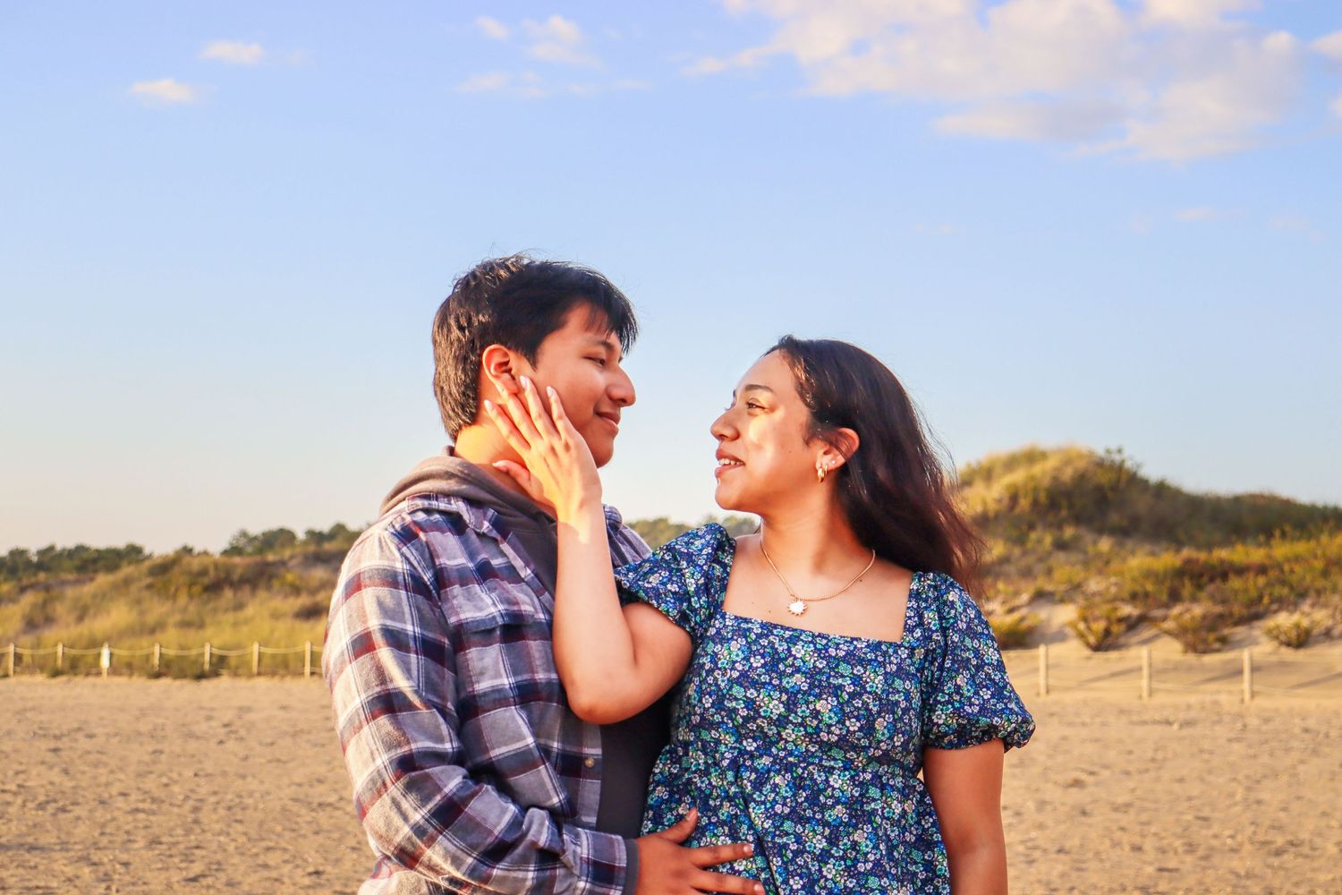Couple sharing intimate moment on beach during sunset.
