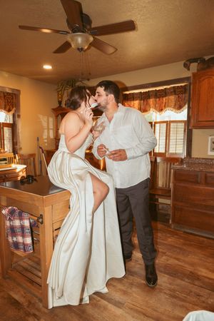 Dancing together in a warm-lit room with hardwood floors and wooden accents.