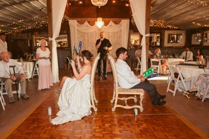 A panoramic view of a rustic barn wedding reception venue with twinkling lights and wooden dance floor.
