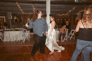 Couple dancing together at a wedding reception venue decorated with string lights.