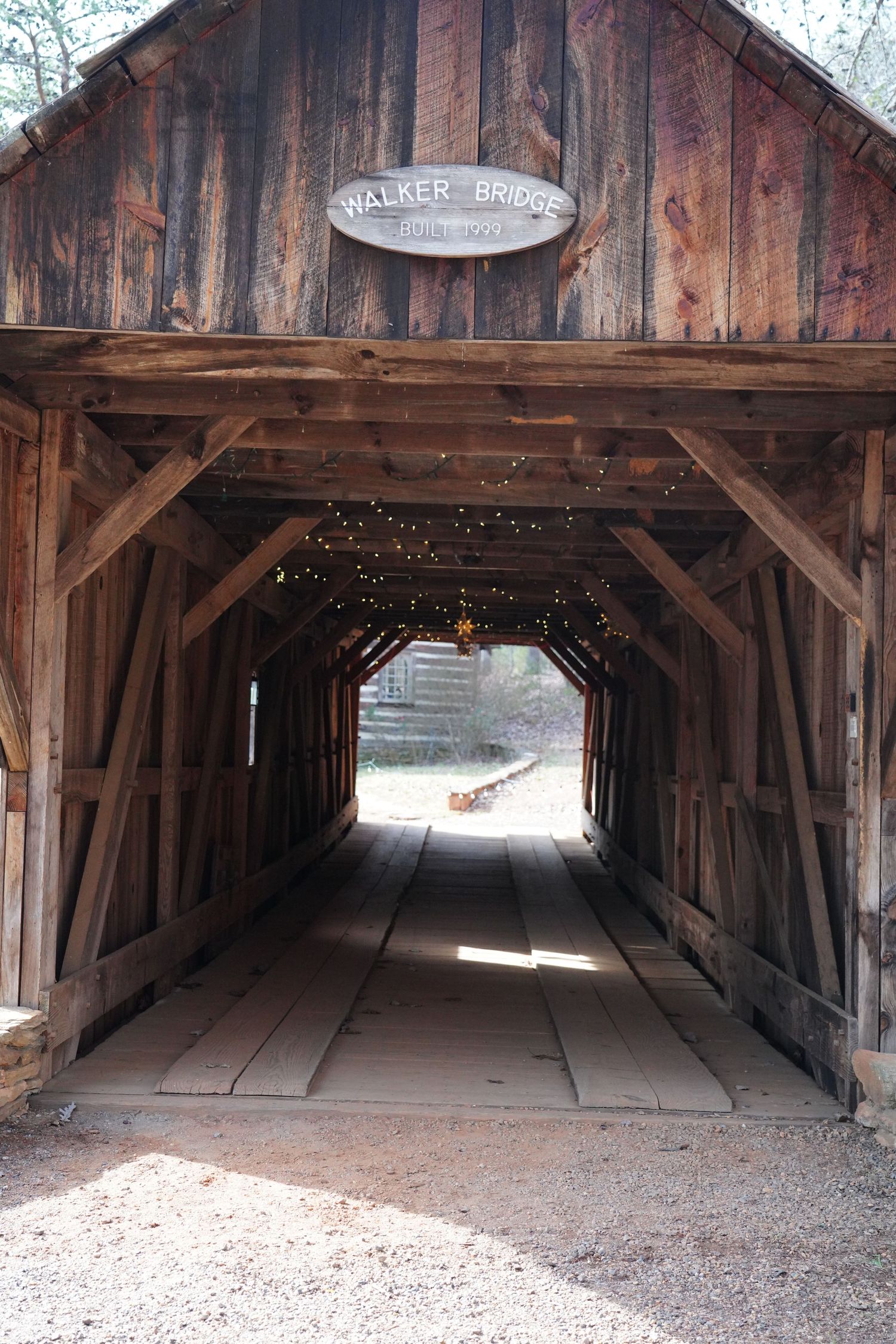 Interior views of an old rustic wooden covered bridge showing its timber frame construction and walkway.