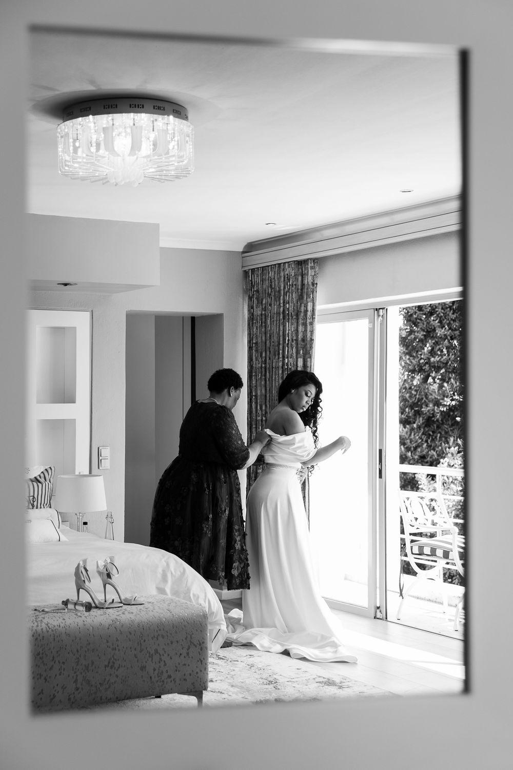 A sequence of black and white interior photos showing a bright room with large windows and modern crystal light fixtures.