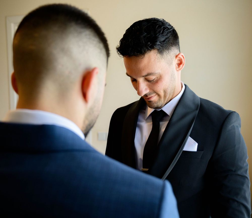Candid shots of men dressed in dark suits preparing for formal occasion.