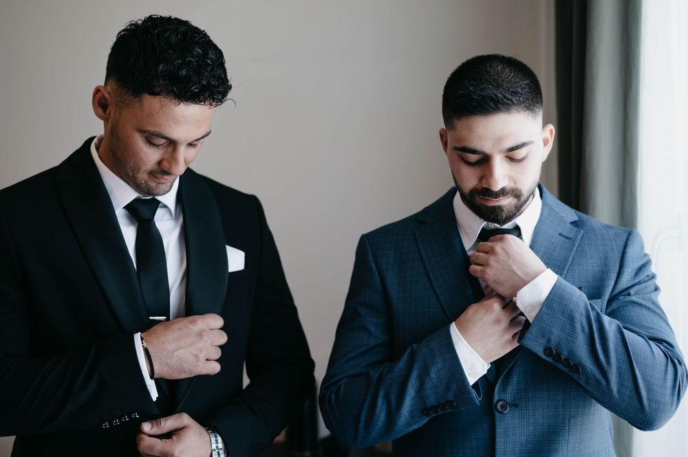 Series of monochrome shots showing men in suits getting ready.