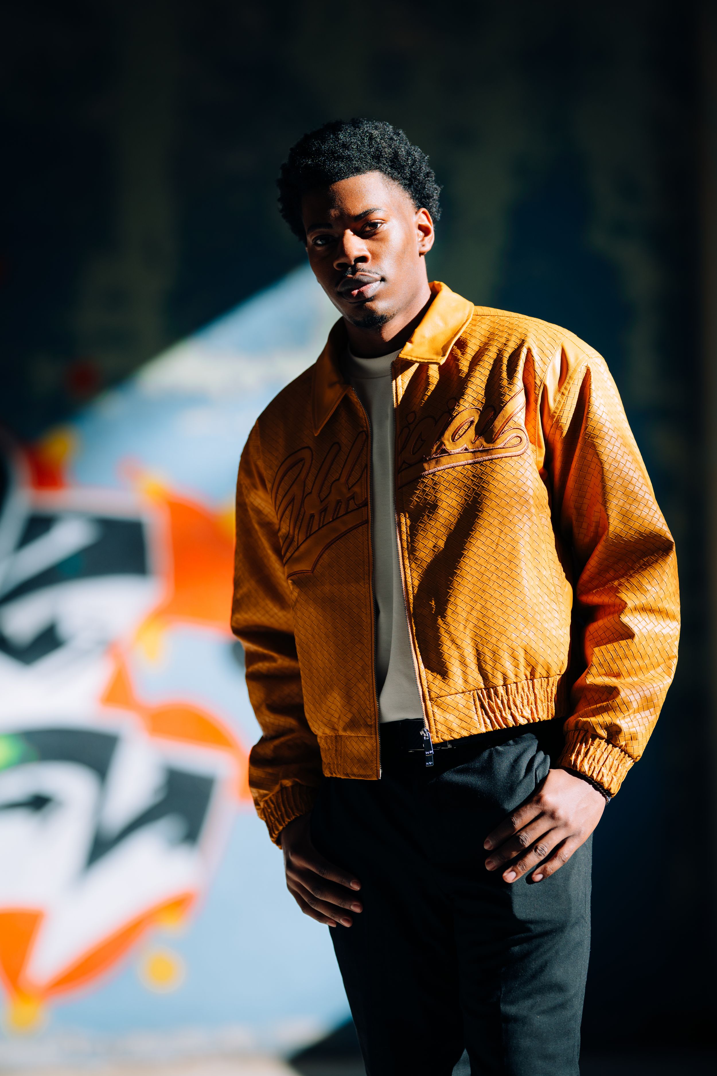 Artistic portrait series showing a person in a yellow jacket against a dark background with blurred lights.