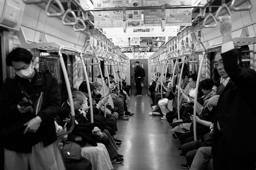 Interior view of a subway car with passengers during commute hours.
