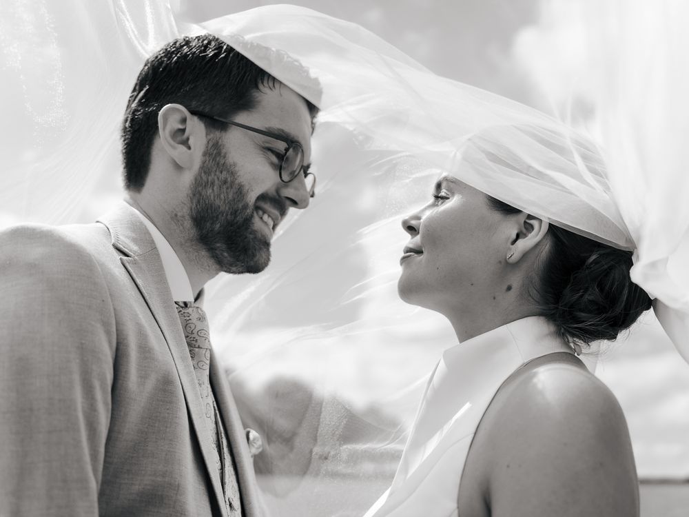 Portraits de mariage intimes capturés à travers un tissu blanc transparent. Florent Vause