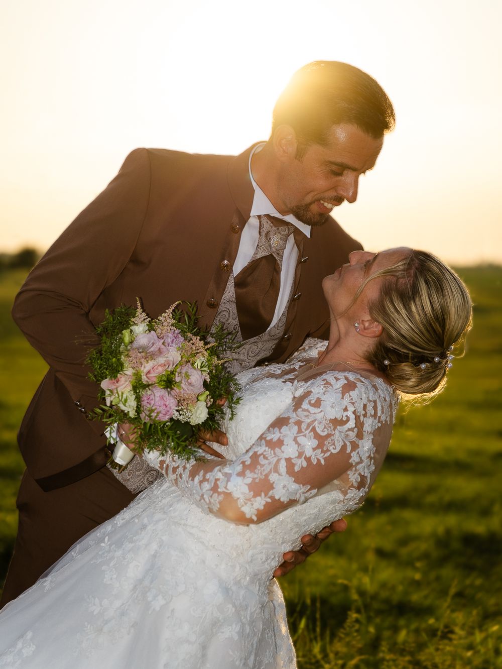 Poses romantiques d'un couple en tenue de mariage capturées pendant l'heure d'or dans un pré. Florent Vause