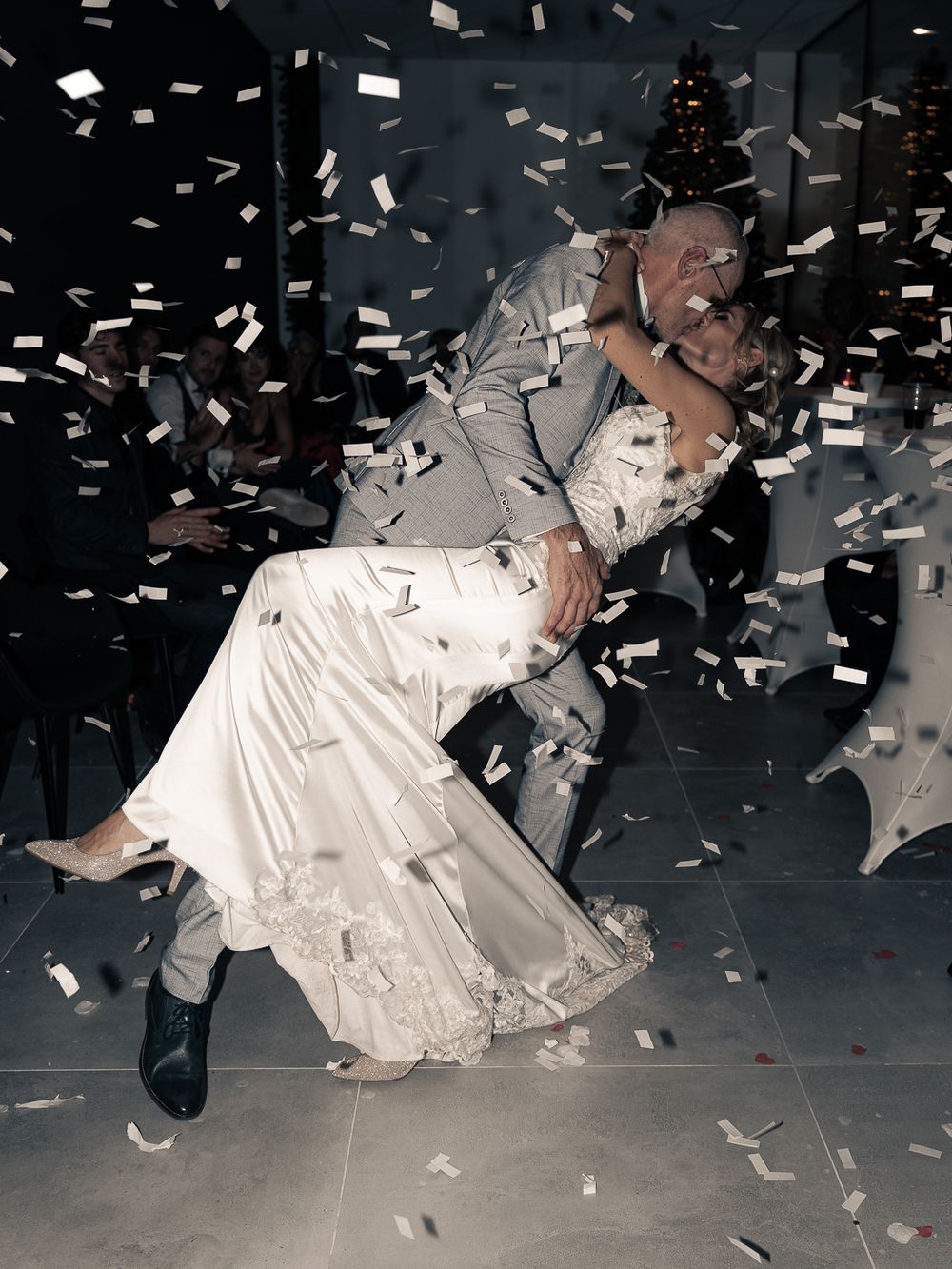 Scène de célébration de mariage avec des confettis volant dans les airs sous un éclairage spectaculaire. Florent Vause